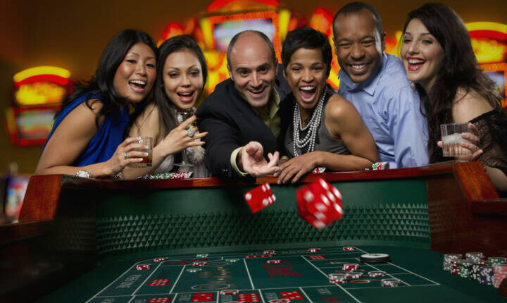 Excited friends gambling at craps table in casino